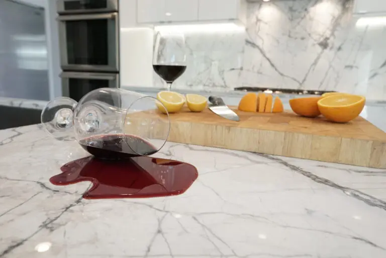 Red wine spilled across a white marble benchtop